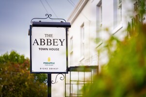 Señalización de 'The Abbey Town House' con un número de contacto.