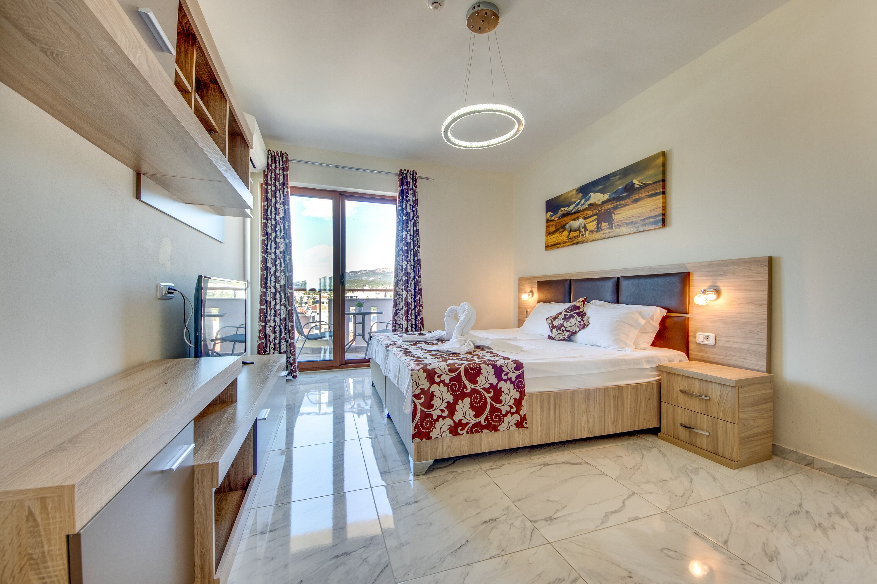 Una moderna camera d'albergo con un letto, comodini, una scrivania e vista sull'esterno.
