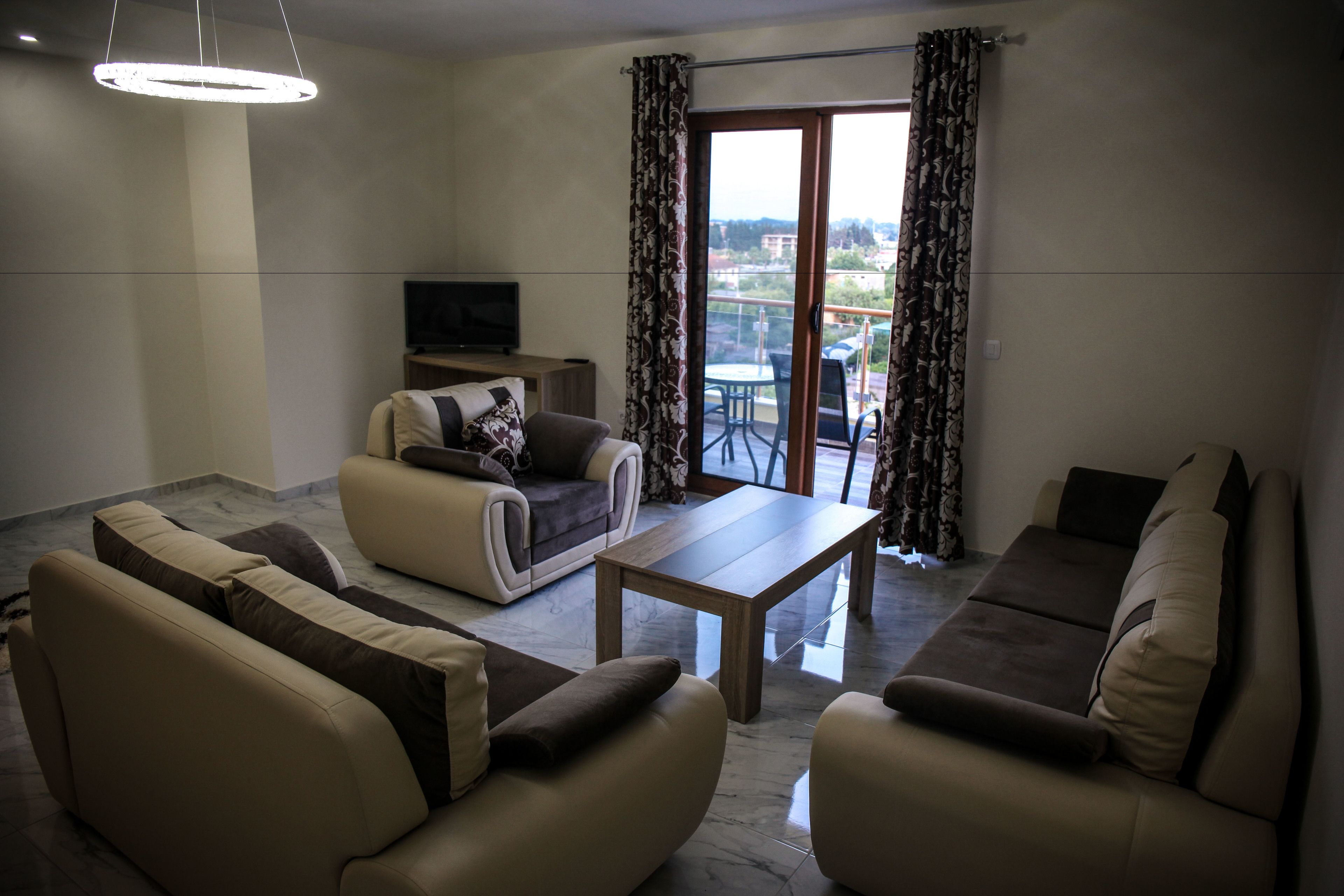 A living room with a sofa set, a coffee table, and a TV.
