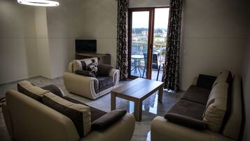 A living room with a sofa set, a coffee table, and a TV.