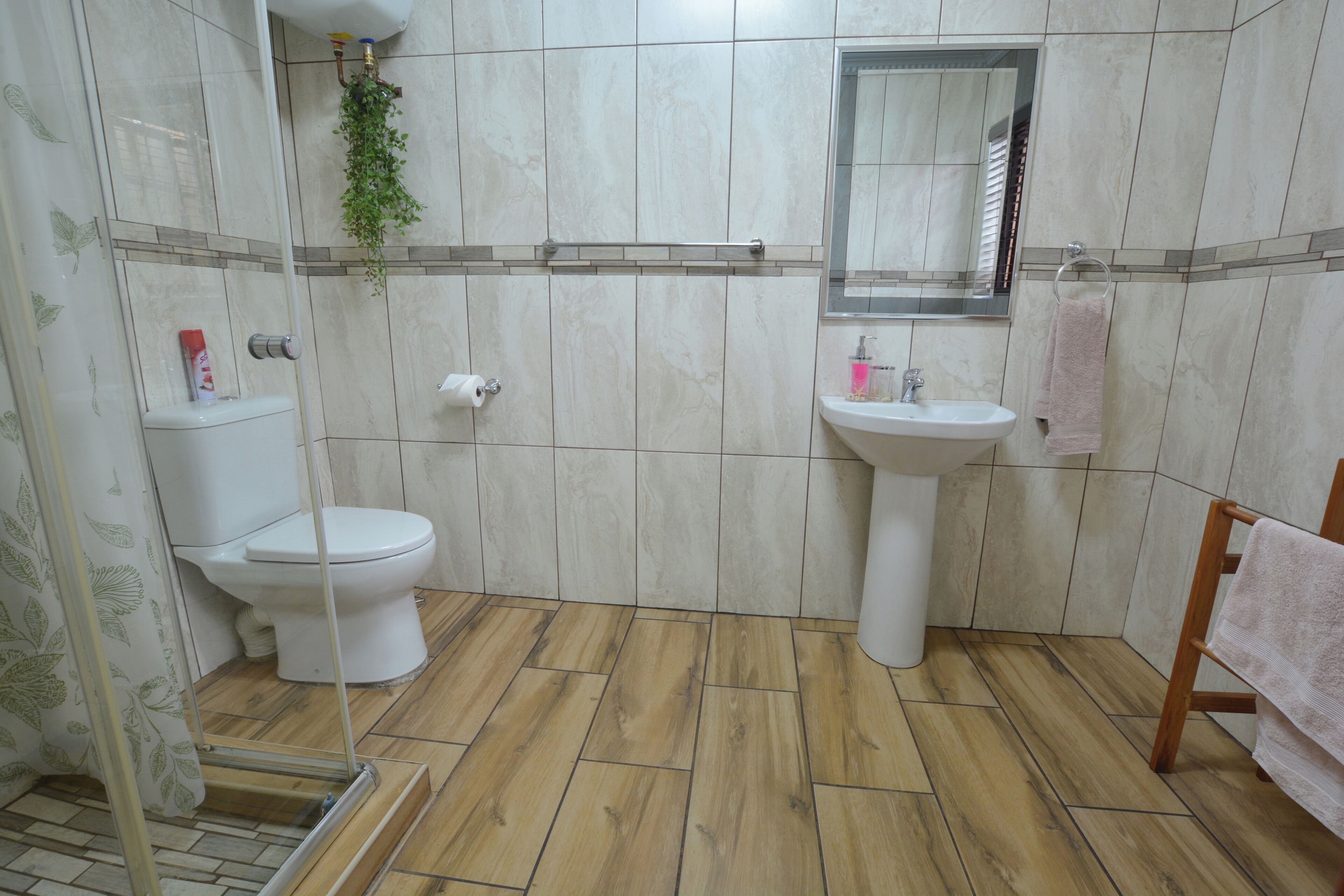 Une salle de bain avec des toilettes, un lavabo et un miroir.