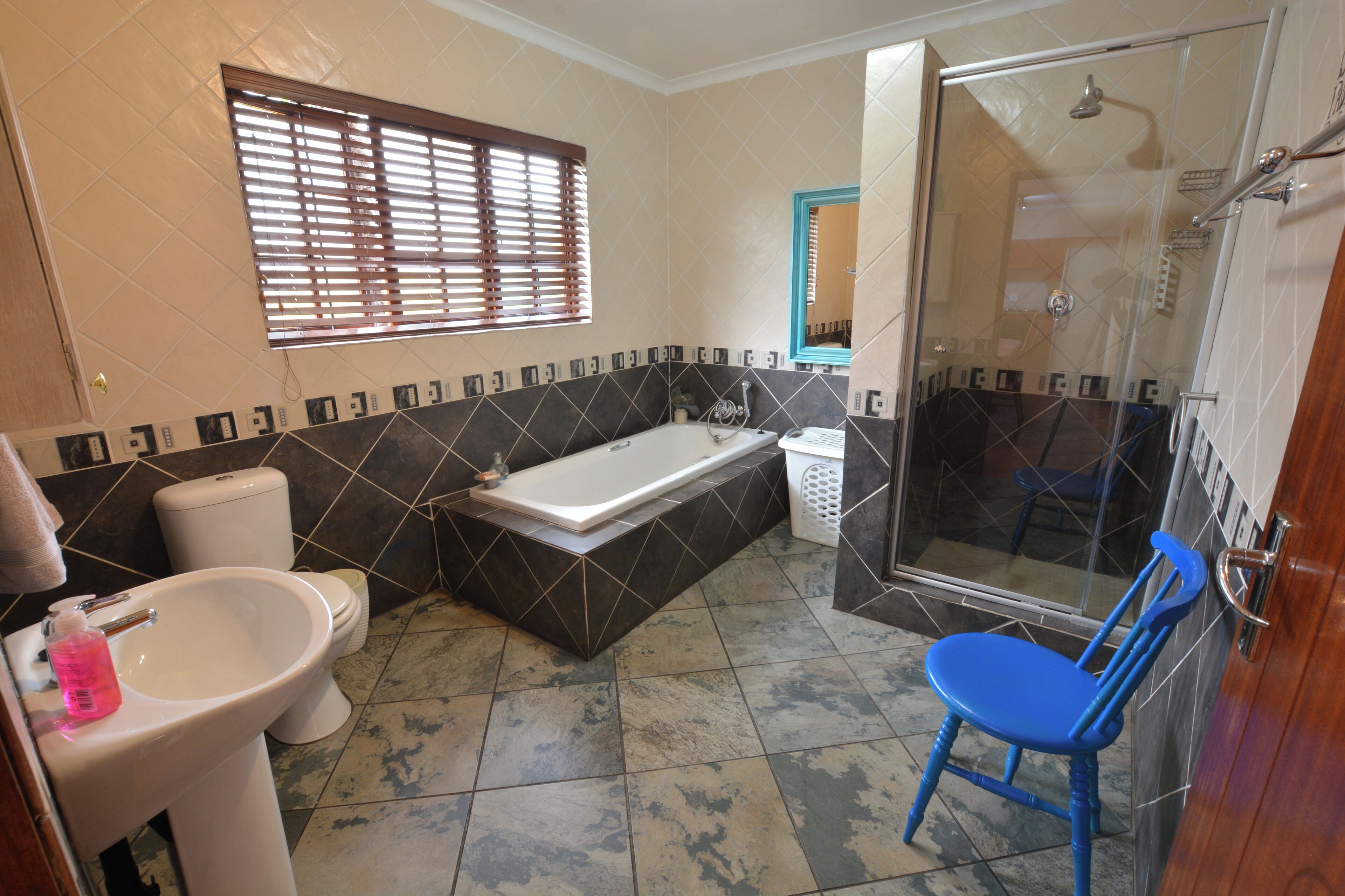 Une salle de bain comprenant une baignoire, des toilettes, un lavabo et un espace douche.