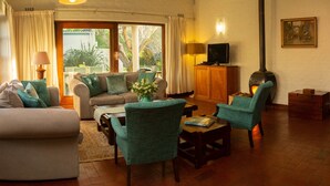 Una sala de estar acogedora con sofá, sillones, televisión y chimenea.