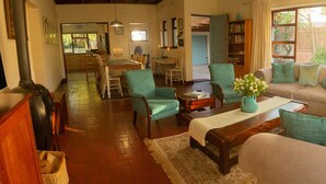Una sala de estar acogedora con sofá, sillones, una mesa de centro y una chimenea.