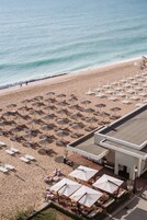 En la playa, sillas reclinables de playa, sombrillas, toallas de playa