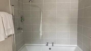A modern bathroom with a glass-enclosed shower, a bathtub, and tiled walls.