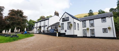 Um edifício branco tradicional com uma placa que diz 'The Village Inn'.