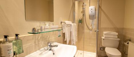 A bathroom with a glass-enclosed shower, a white sink, and a toilet.