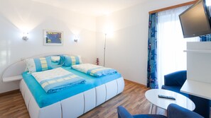 A modern hotel room with a bed, a desk, a chair, and a TV. - Apartments Presslauer-Mori (Sankt Kanzian am Klopeiner See)