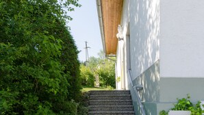 A stone staircase leading up to a building with a wooden overhang.