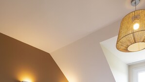 A bedroom with two beds, a sloped ceiling, and a large window. - Résidence Odalys Les Villas de la Baie (Le Crotoy)
