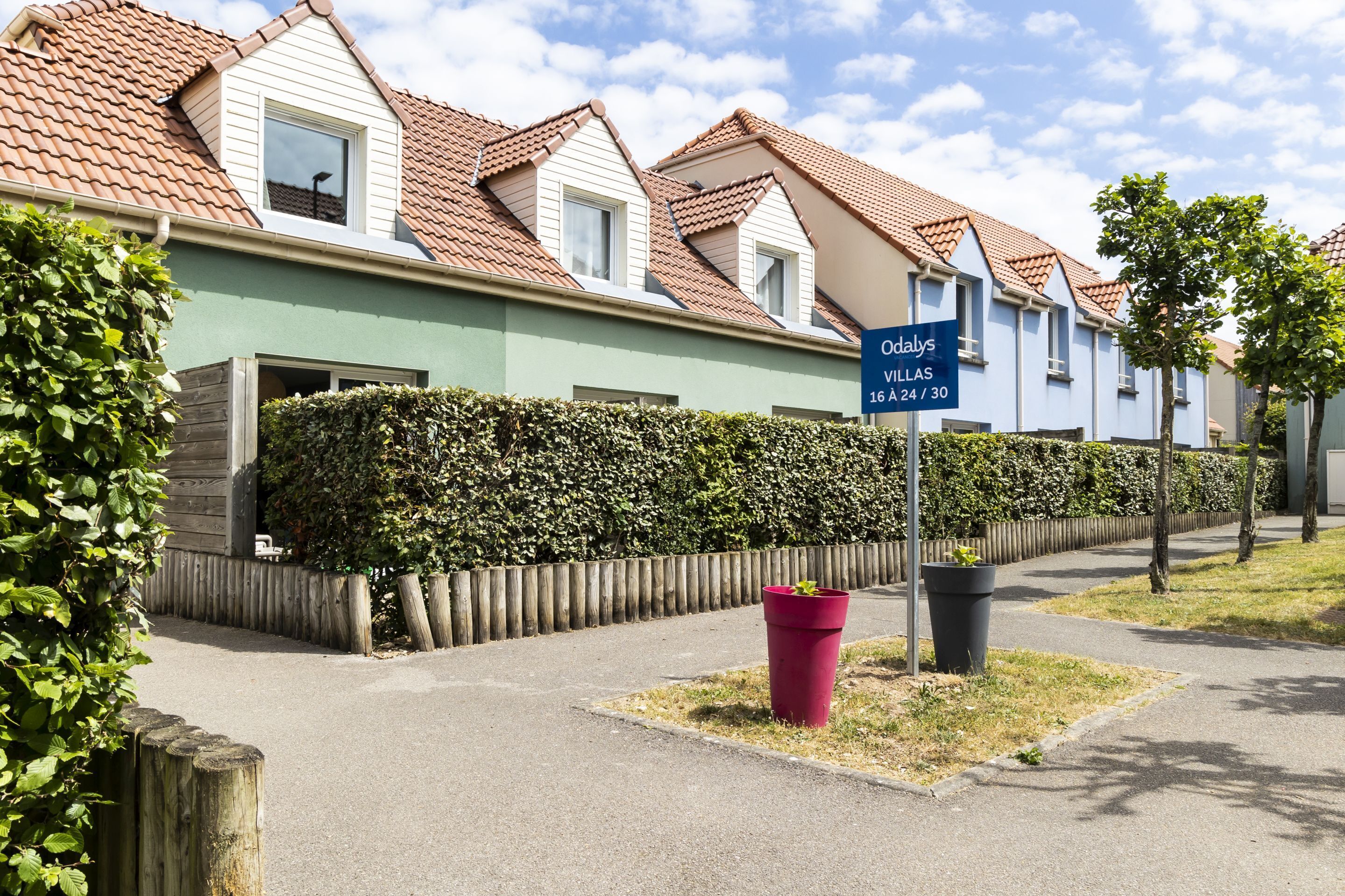 A row of townhouses with a sign indicating 'Odalys Villas 16 A 24 / 30'.