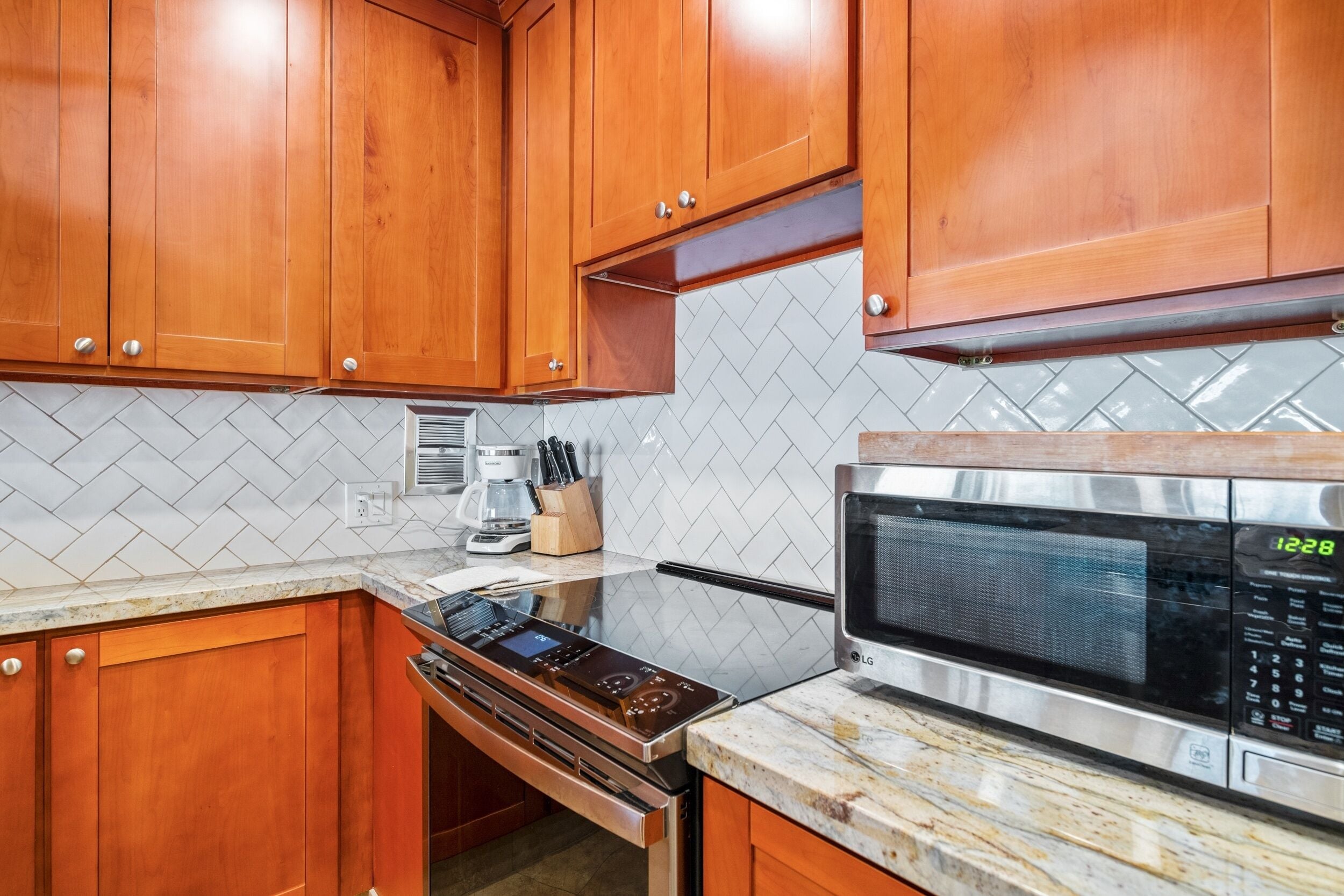 A kitchen with wooden cabinets, a microwave, and a stove.