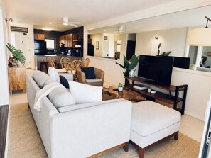 A living room with a sofa, chairs, a coffee table, and a television. - Kona Bali Kai 223 - Oceanfront 2 Bedroom Condo by RedAwning (Kailua-Kona)