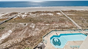 A beach view with a pool area featuring a logo, a deck, and lounge chairs. - Phoenix VII 71113 by ALBVR (Orange Beach)