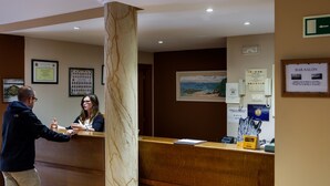 A reception area with a marble column, framed certificates on the wall, and a Bar-Salon sign.