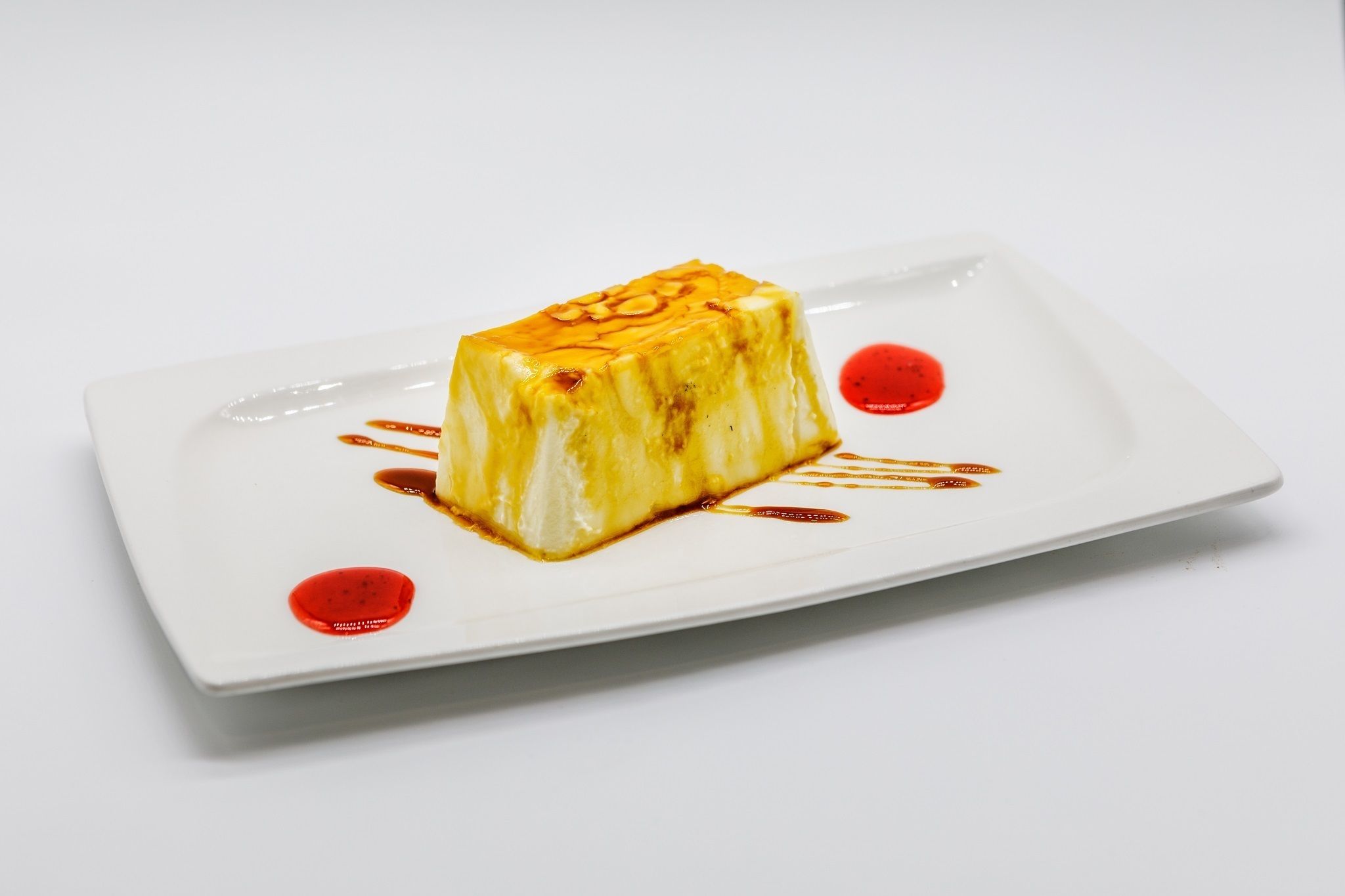 A dessert on a white plate with a square design.