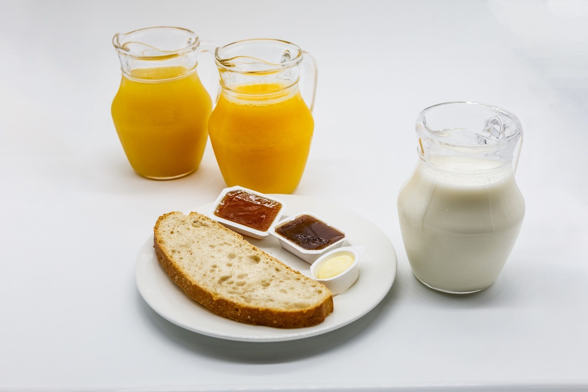A breakfast setting with toast, butter, jam, and milk.