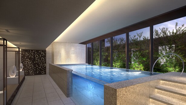 A modern indoor swimming pool with a view of greenery outside, surrounded by stone walls and large windows. - Ascott Marunouchi Tokyo (Tokyo)