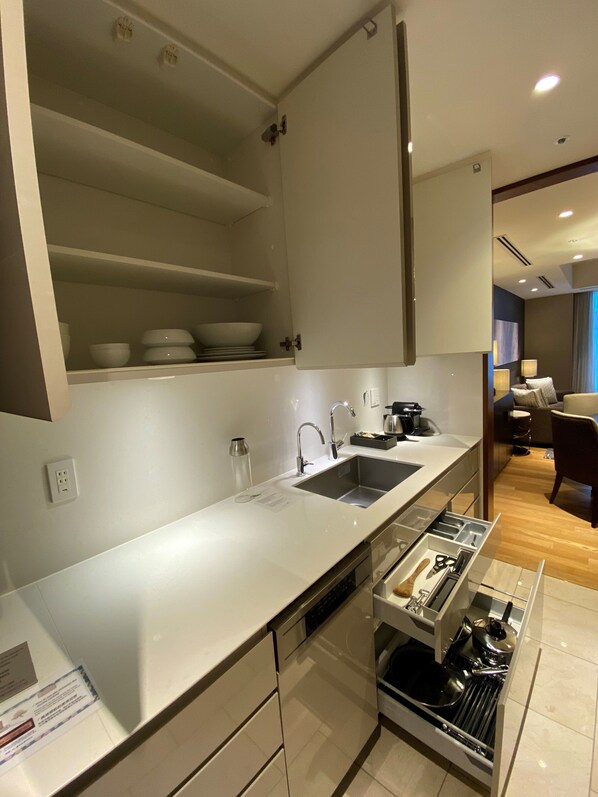 A modern kitchen with a built-in dishwasher, a double sink, and a countertop with a dish rack. - Ascott Marunouchi Tokyo (Tokyo)
