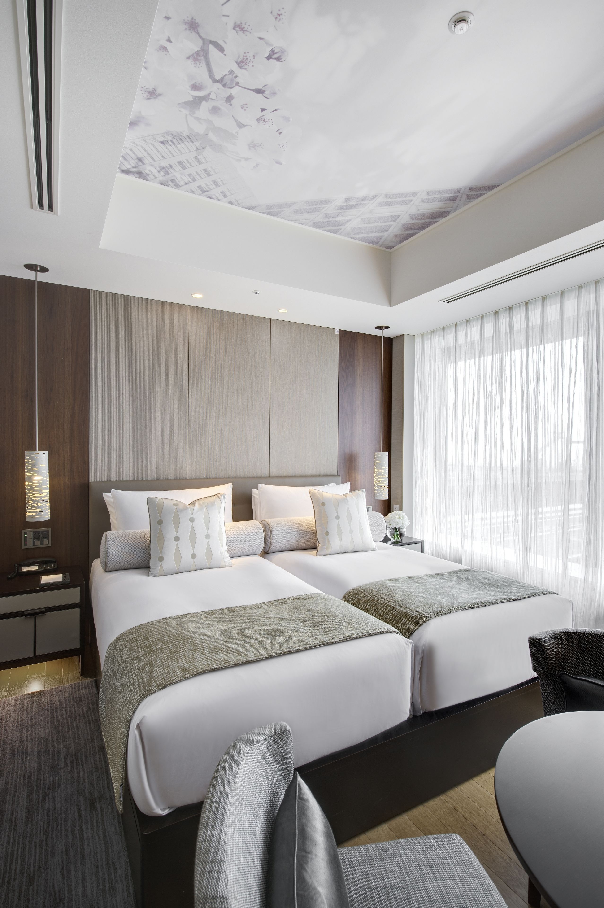 A modern hotel room with a large bed, a desk, and a chair.