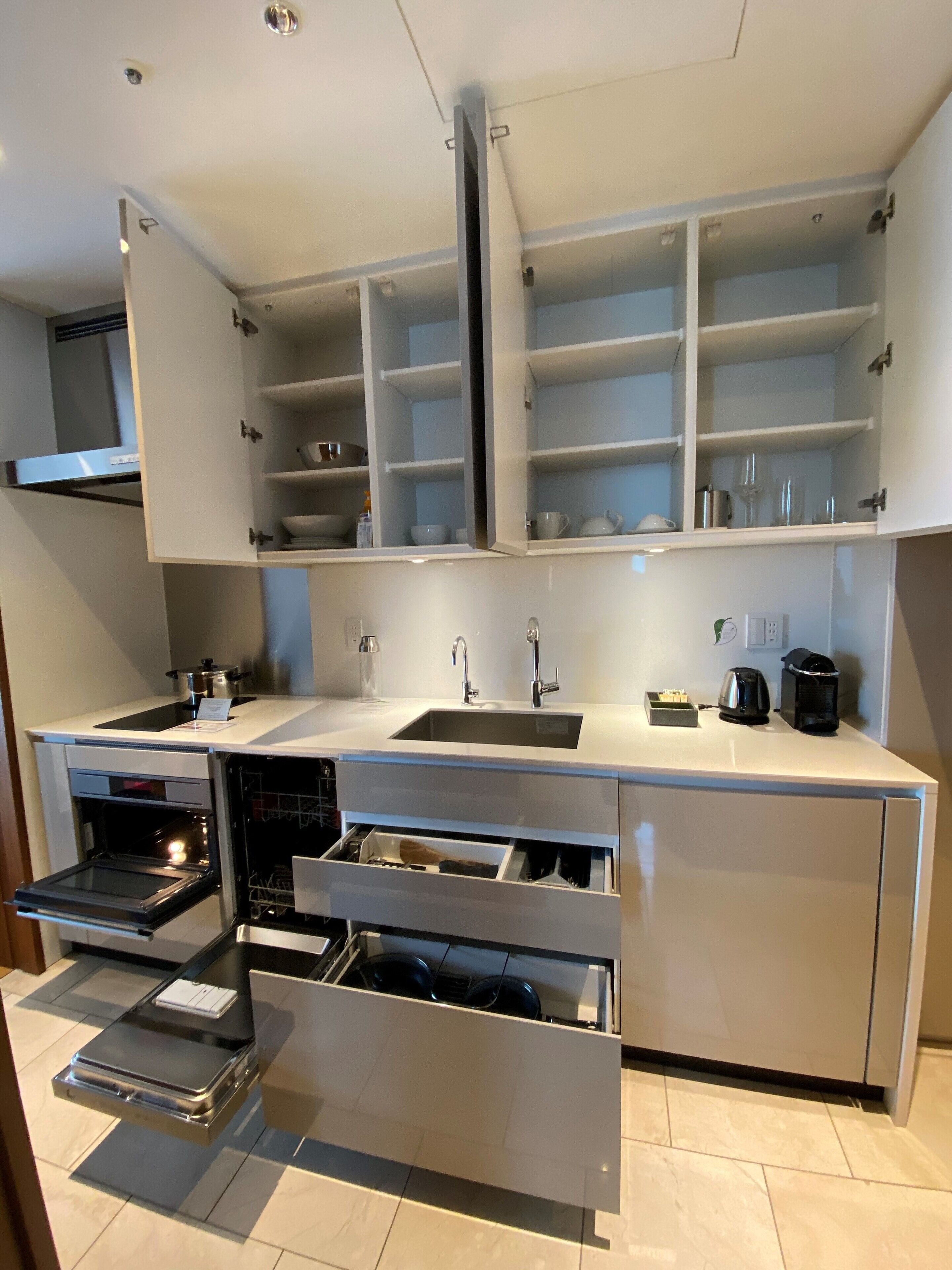 A modern kitchen with built-in cabinets, a stainless steel sink, and a built-in oven.