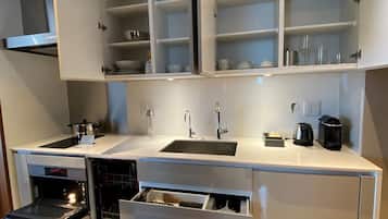A modern kitchen with built-in cabinets, a stainless steel sink, and a built-in oven.
