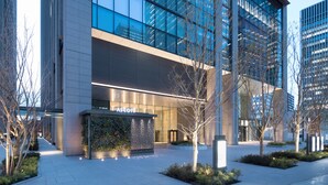 A modern building with a glass facade, a landscaped entrance, and a sign that reads "ASCOTT." - Ascott Marunouchi Tokyo (Tokyo)