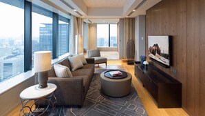 A modern living room with a large window, a sofa, a coffee table, and a flat-screen TV. - Ascott Marunouchi Tokyo (Tokyo)