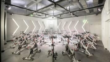 Un gimnasio con varias bicicletas estáticas dispuestas en filas.