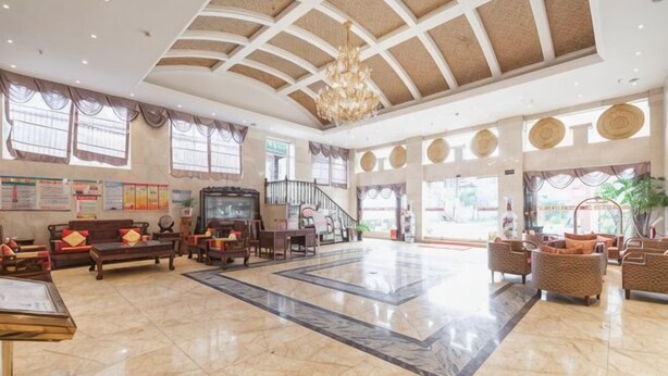 A spacious lobby with a high ceiling, a chandelier, a staircase, and comfortable seating areas. - Fortune Hotel (Mangshi)