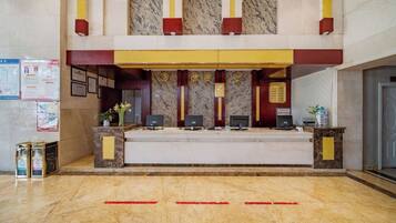 A reception desk with a marble floor, a yellow and red color scheme, and a marble wall.