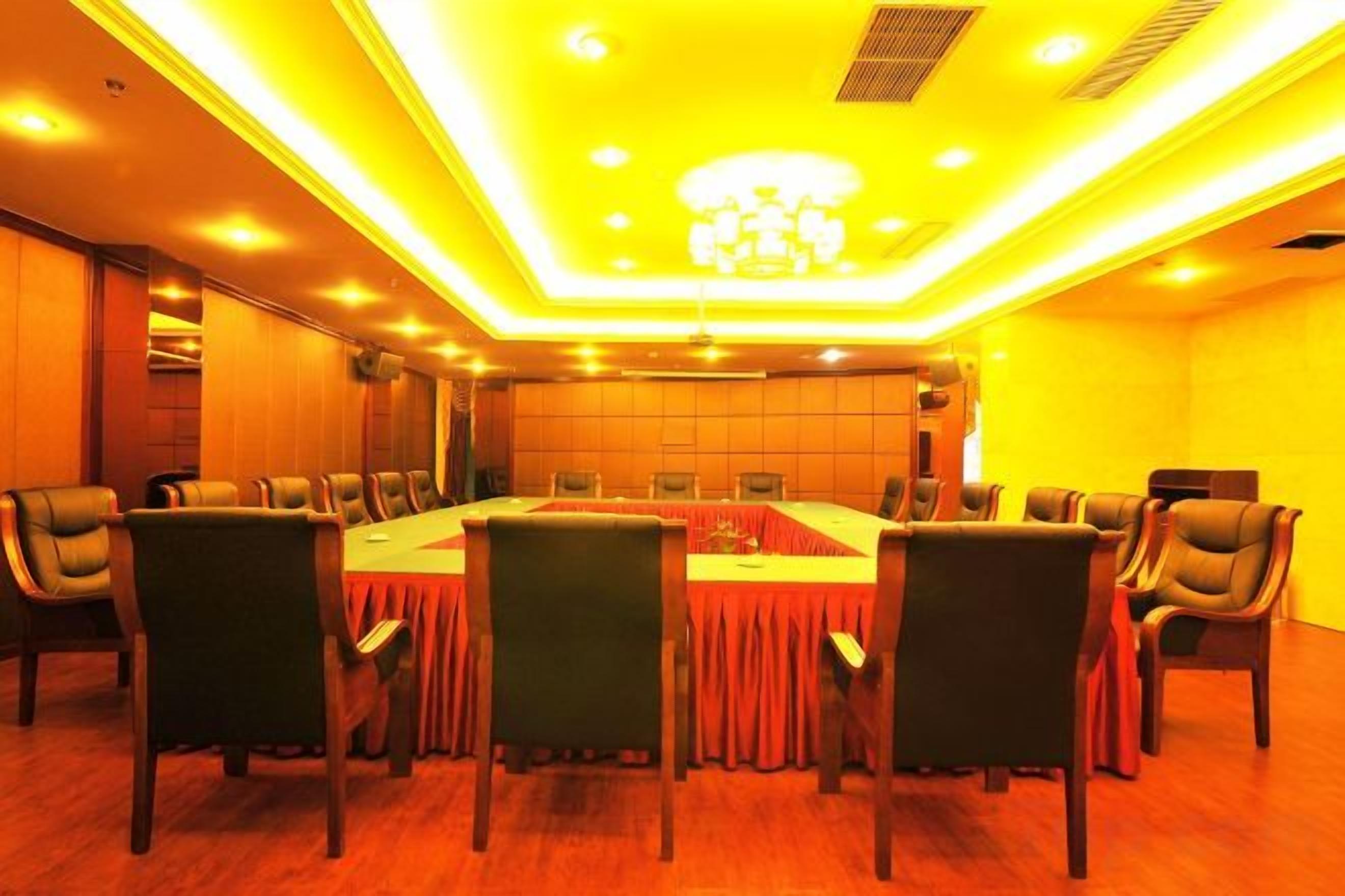 A conference room with a long table, chairs, and a chandelier.