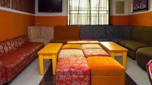 Una sala de estar con sofá, otomanas y una mesa de centro.