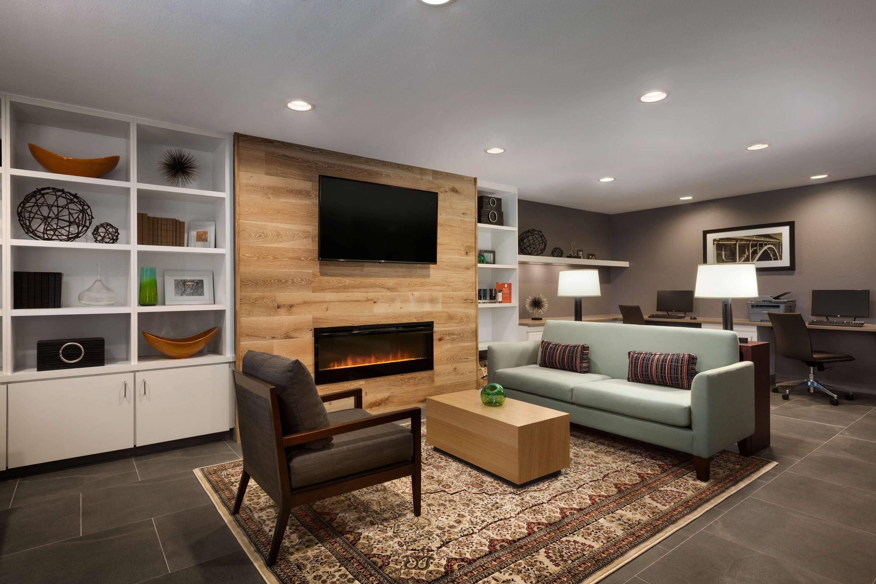 A modern living room with a fireplace, a flat-screen TV, a sofa, and a coffee table.