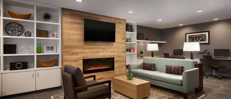 A modern living room with a fireplace, a flat-screen TV, a sofa, and a coffee table.