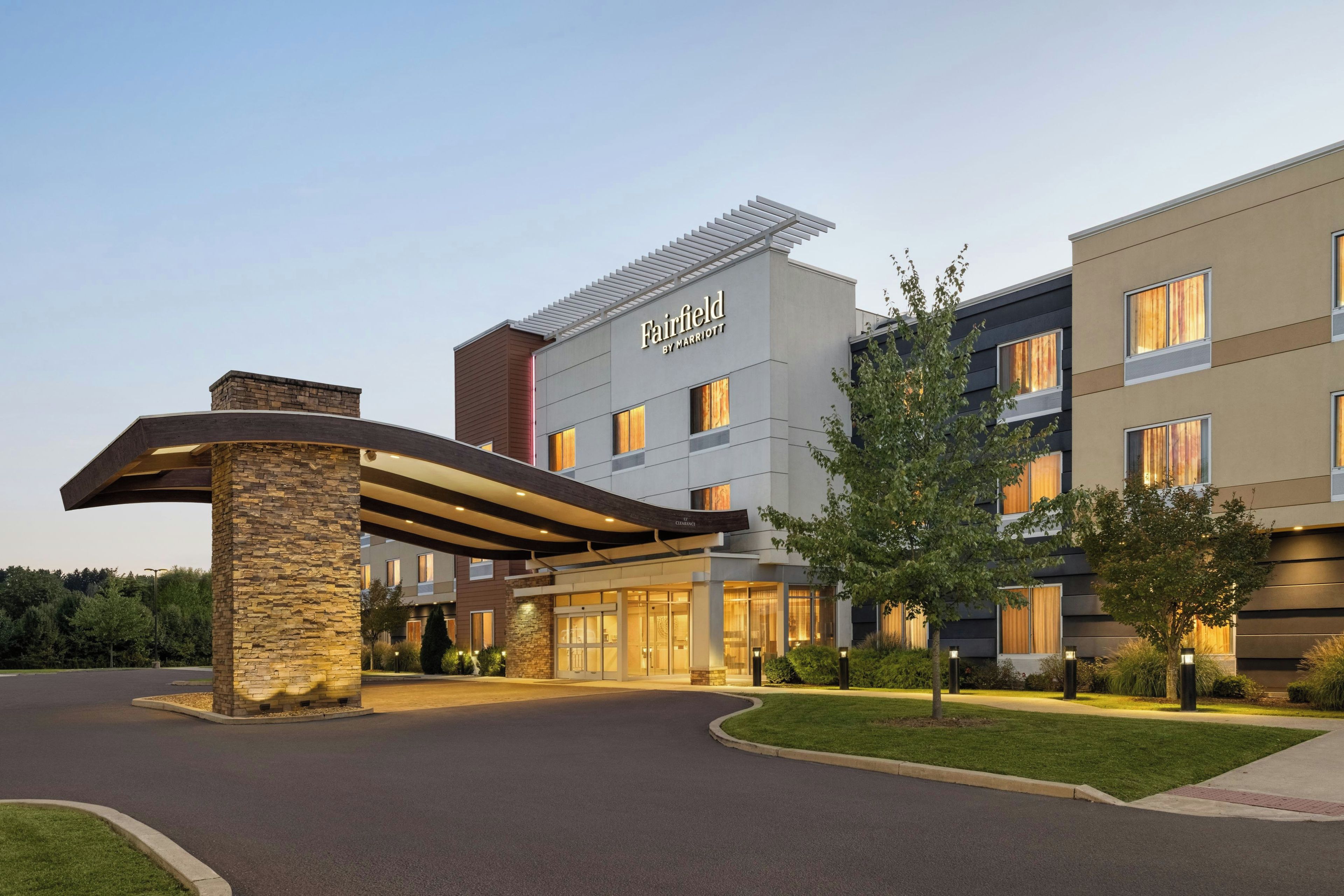 A hotel with a modern entrance, a covered walkway, and a sign indicating it's a Marriott property.