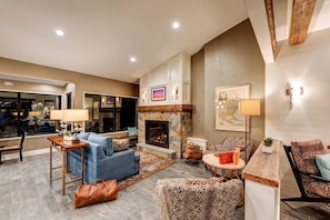 A living room with a fireplace, seating, and a view of the outside.