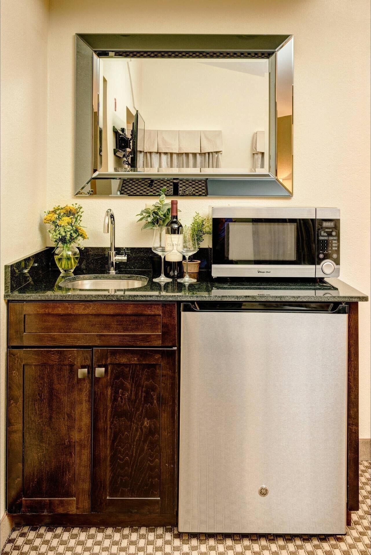 A compact kitchen with a built-in microwave, a sink, and a refrigerator.