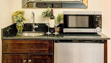 A compact kitchen with a built-in microwave, a sink, and a refrigerator.