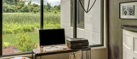 A modern office space with a desk, computer, printer, and chair.