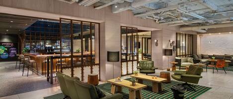 A modern lounge area with a bar, seating, and a view of the bar area.