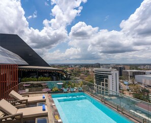 A rooftop pool with lounge chairs, a bar area, and a view of the cityscape. - Park Inn by Radisson Nairobi Westlands (Nairobi)