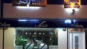 Entrada de un hotel con un cartel que dice 'Zafara Hotel' y un logotipo sobre la puerta.