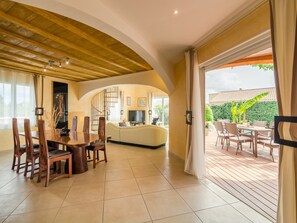 Relax in this inviting living area with a dining table, sofa, and patio access.