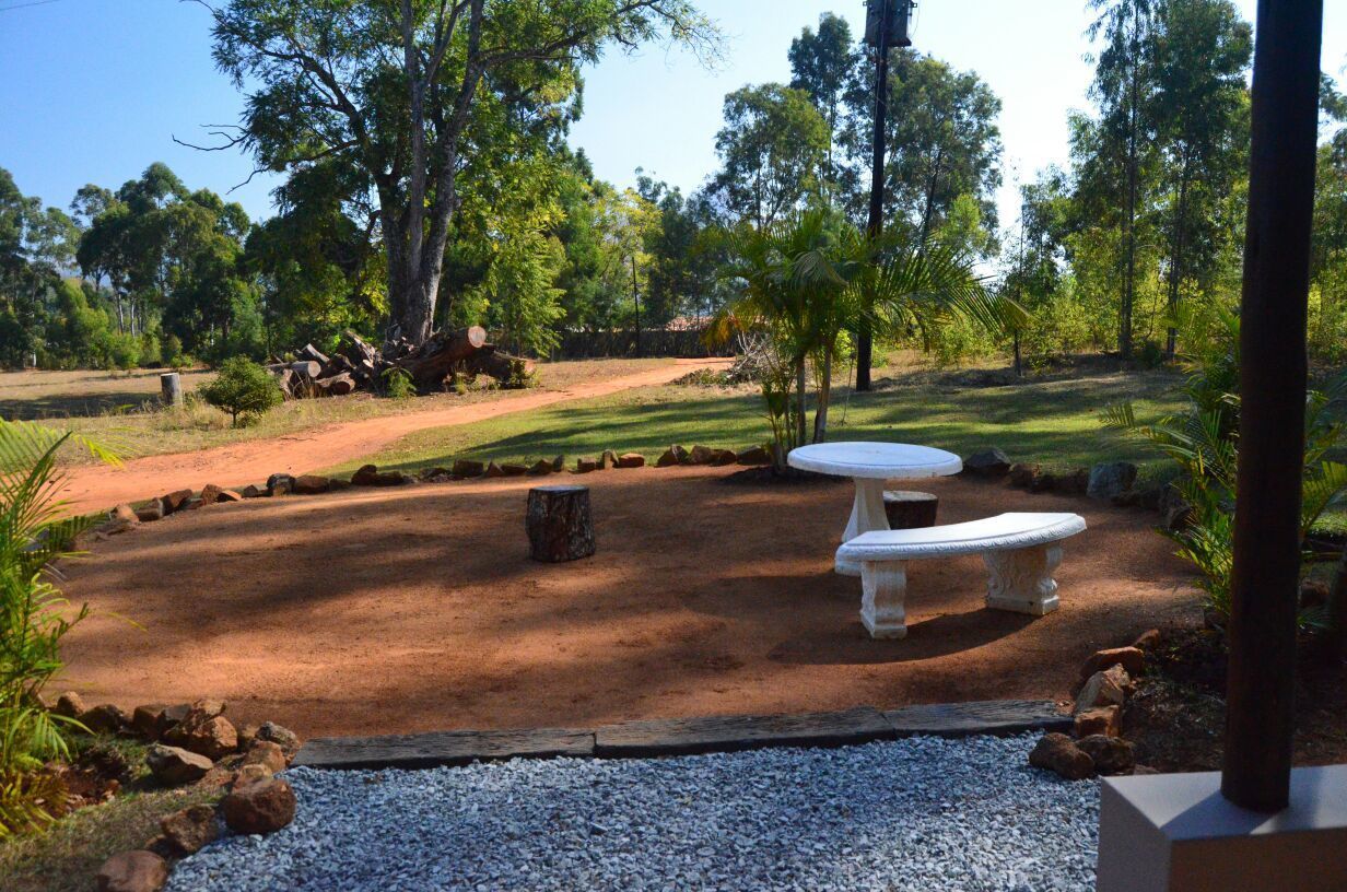 A landscaped outdoor area with a gravel path, a white bench, and a circular table.