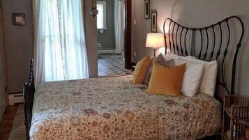 Une chambre à coucher avec un lit, une table de chevet, une lampe et une chaise.