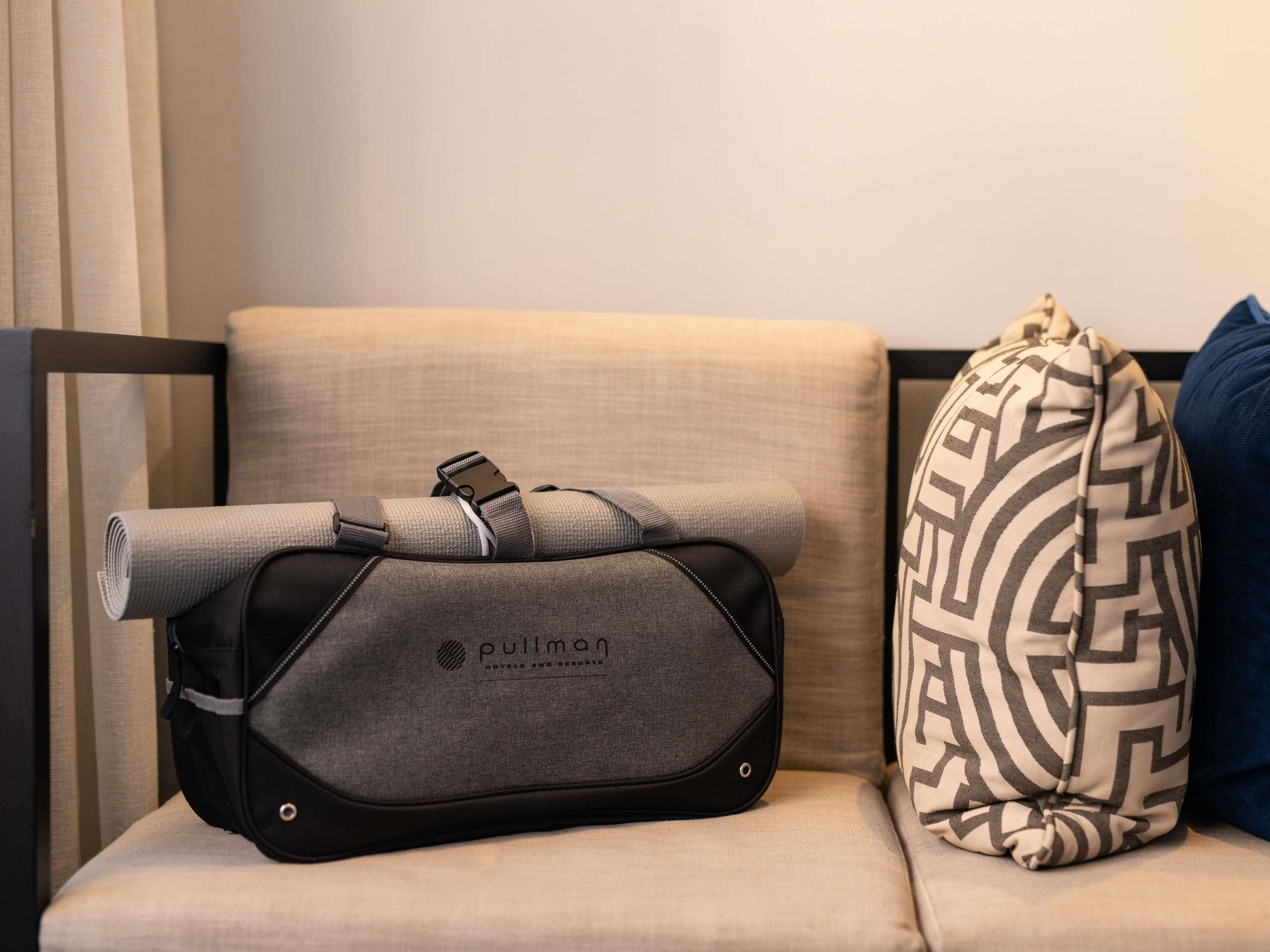 Uma mala tipo pullman e uma mala estampada em um sofá.
