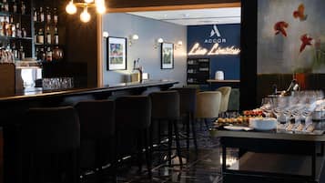 A bar area with a polished floor, bar stools, and a well-stocked liquor shelf.