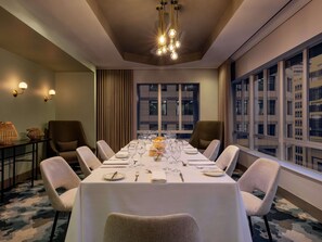 A conference room with a long table set for a meeting, surrounded by chairs, with a cityscape view through large windows. - Pullman Cape Town City Centre (Cape Town)